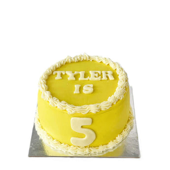 Personalized dog birthday cake for Tyler's 5th birthday celebration with yellow frosting.